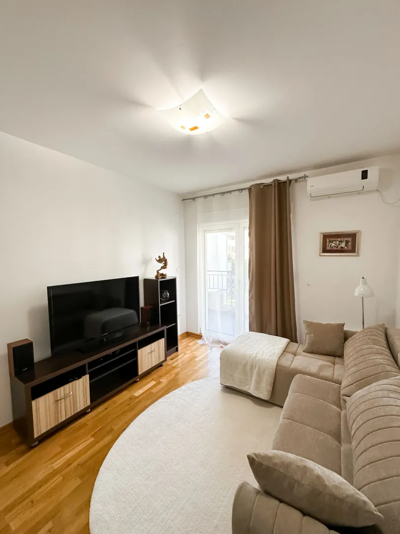 Living room with a sofa, TV, and access to the terrace.