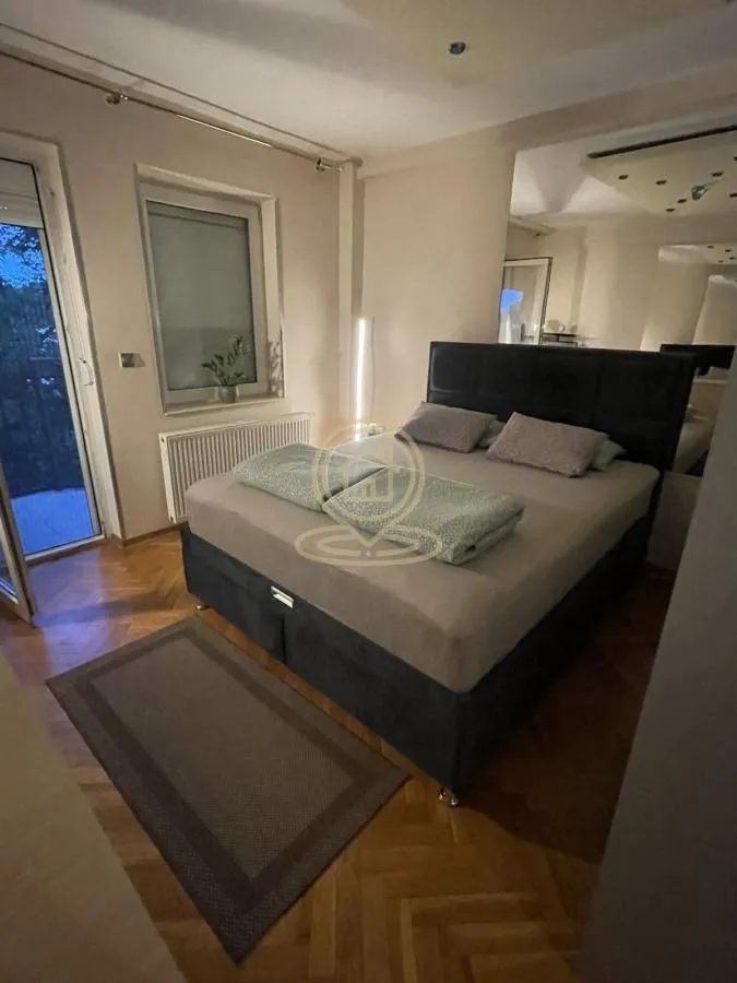 Bedroom with a double bed, parquet flooring, and access to the terrace.
