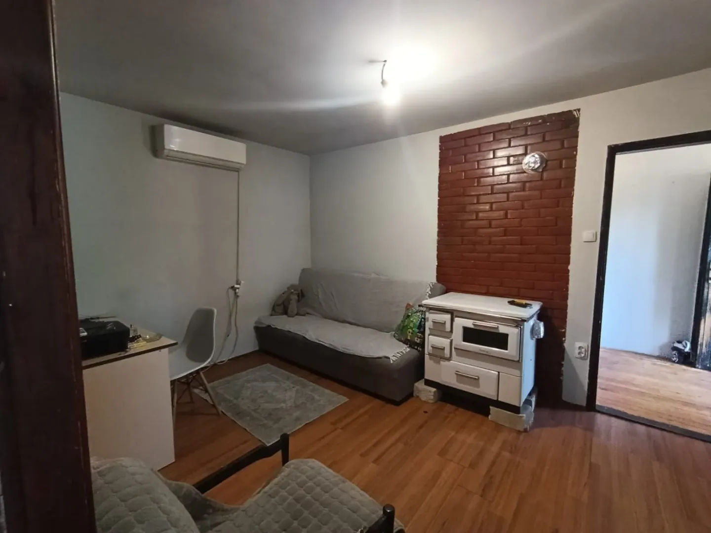 Dnevna soba sa kaučem, peći na drva i radnim stolom.