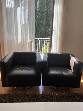 Two leather armchairs positioned in front of a balcony door. - image 4