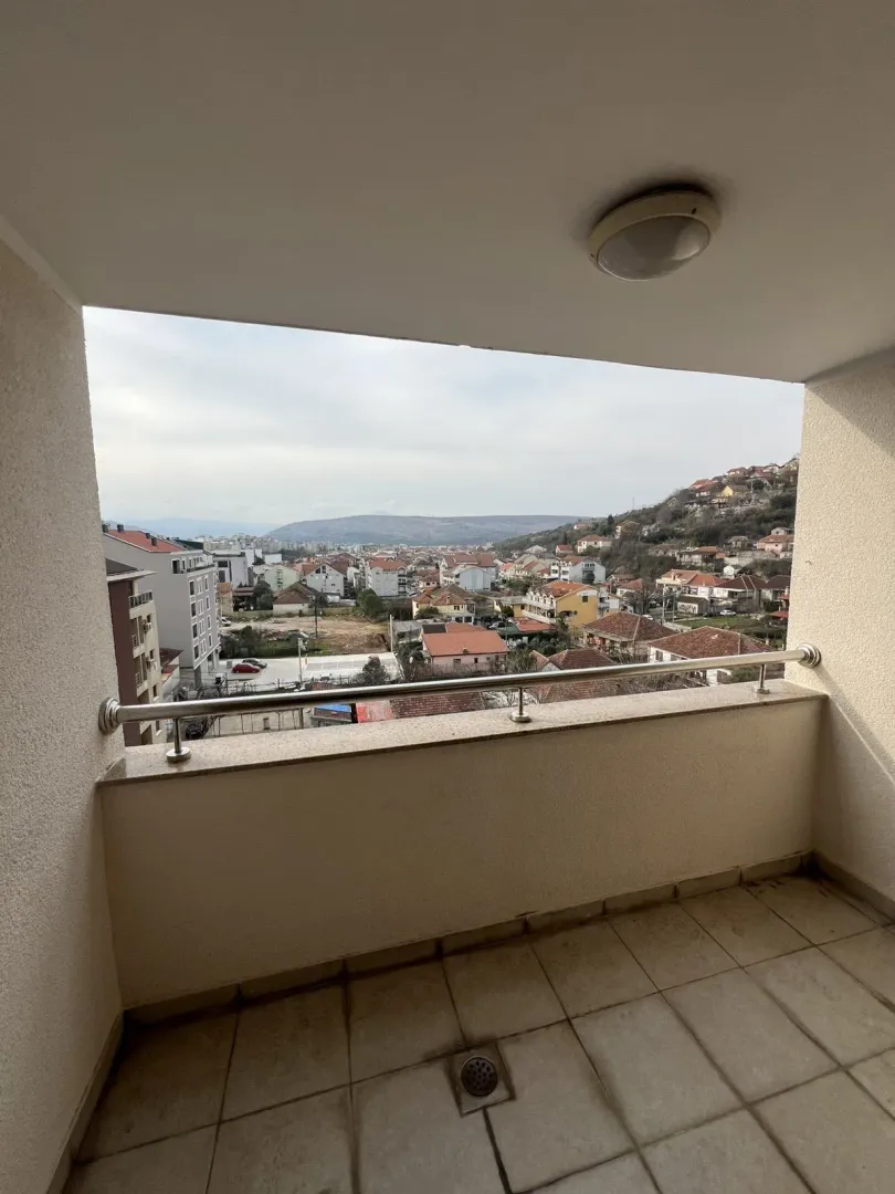 View of the neighborhood and hills from a tiled balcony.