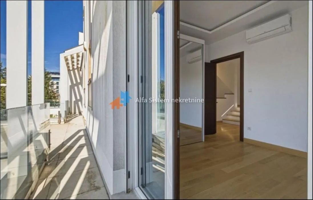View from the terrace towards the interior of a bright room with wooden flooring.