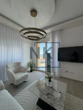 Dnevna soba sa foteljom, stočićem, televizorom i izlazom na terasu. - image 3
