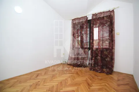 Empty room with parquet flooring and a window with dark red curtains. - image 10
