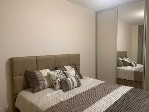 A decorated bedroom with a double bed and a mirrored built-in wardrobe. - image 6