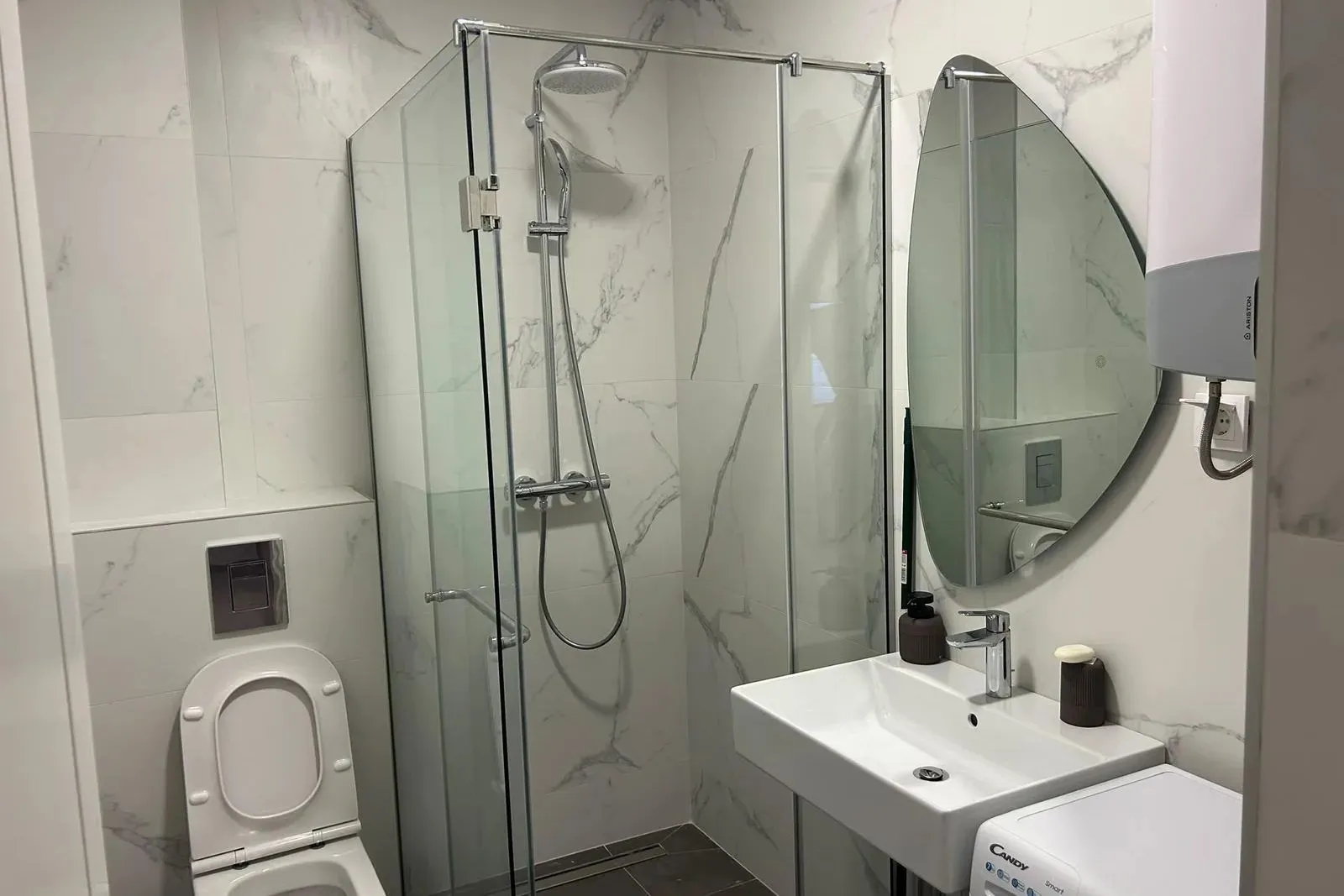 Moderno opremljeno kupatilo sa tuš kabinom, umivaonikom i wc šoljom.