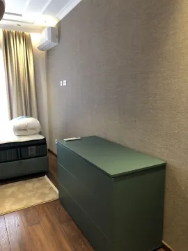 Part of a bedroom with a green dresser and a bed next to the wall. - image 11