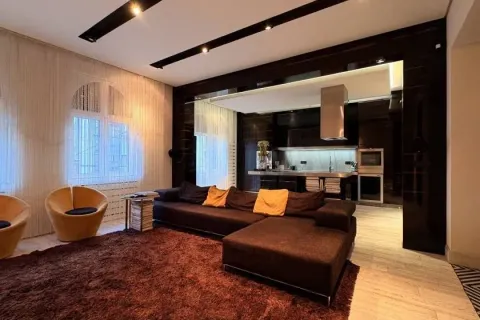 Spacious living room with a sofa and a view of the kitchen. - image 4