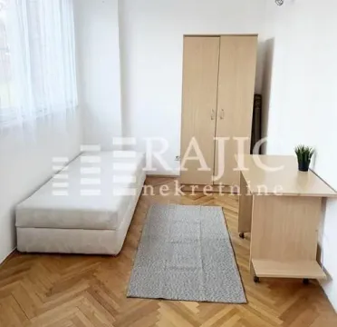 Furnished bedroom with a bed, wardrobe, and desk. - image 5