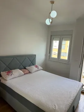 Uređena spavaća soba sa bračnim krevetom i prozorom. - image 3