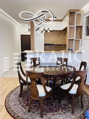 Dining area with a wooden table and chairs, connected to the kitchen.