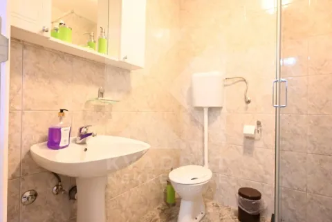 Bathroom equipped with a washbasin, toilet, and shower cabin, tiled with ceramic tiles. - image 23