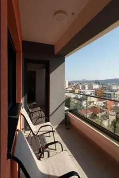 Natkrivena terasa sa garniturom za sjedenje i pogledom na grad. - image 8