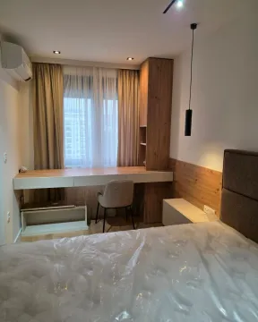 Modern bedroom with a double bed, desk, and built-in wardrobe. - image 9