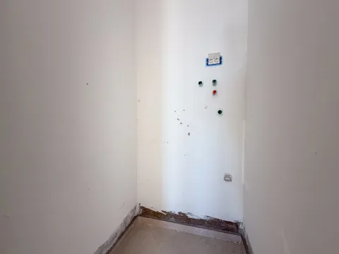 Prazan dio prostorije sa priključcima na bijelom zidu i keramičkim pločicama na podu. - image 10