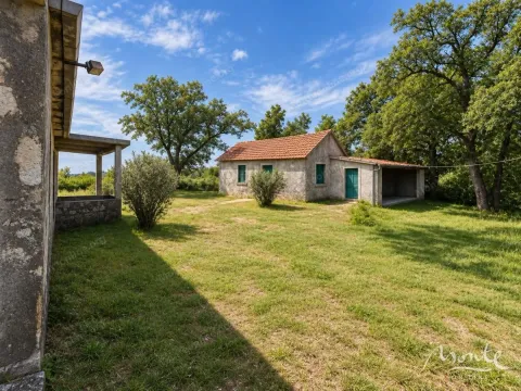 View of the yard and old stone buildings surrounded by greenery and trees. - image 2