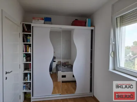 Spavaća soba sa velikim belim ormarom i krevetom. - image 10