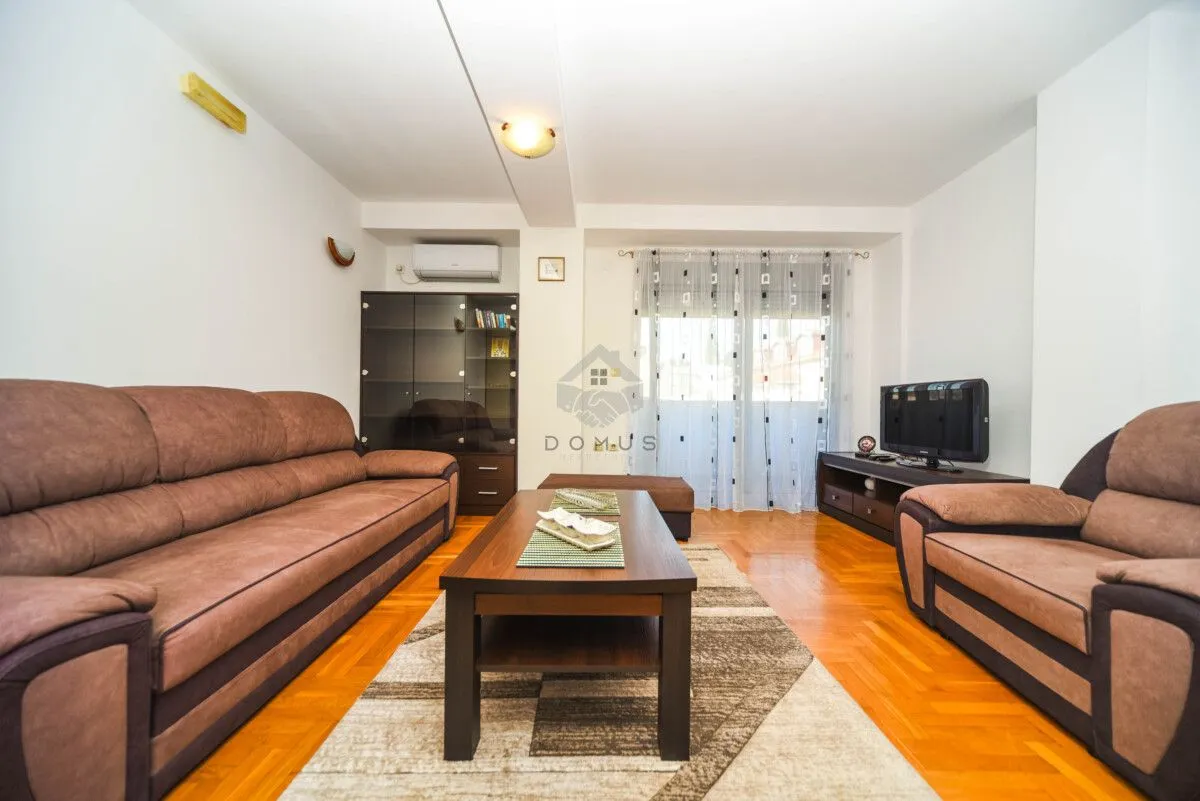 Living room with sofa set, coffee table, and television.