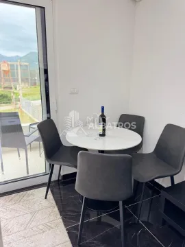 Dining corner with a round table and four chairs next to the balcony door. - image 2