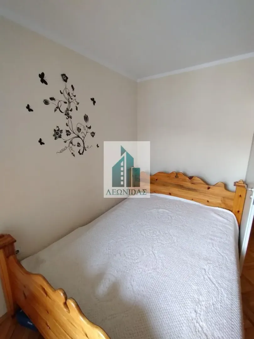 Bedroom with a wooden bed and decorative wall stickers.