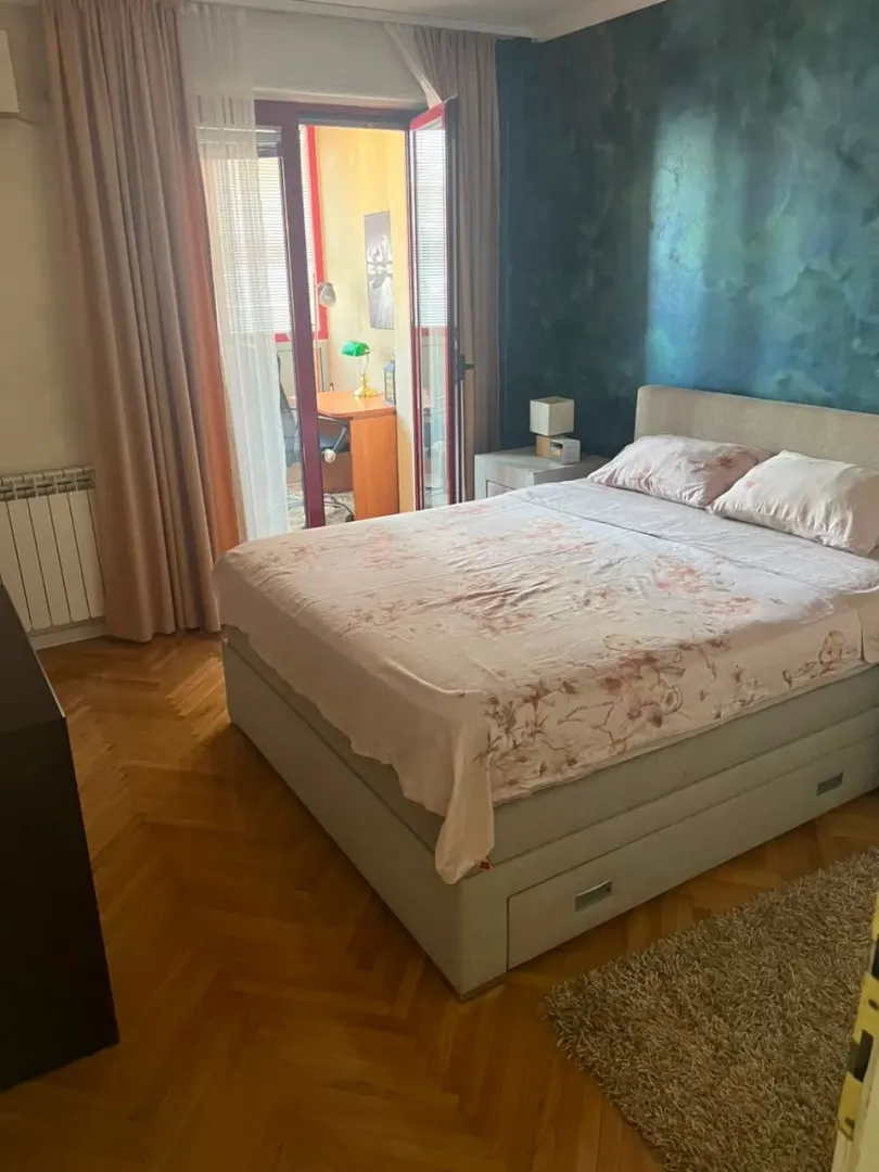 Spavaća soba sa bračnim krevetom i izlazom na terasu.