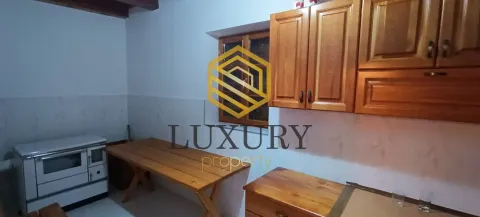 Smaller kitchen with wooden cabinets and a dining table. - image 5
