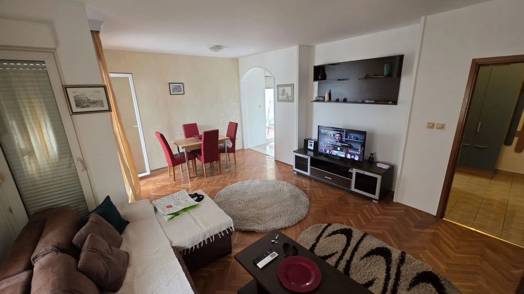 Bright living room with a dining area and parquet flooring.