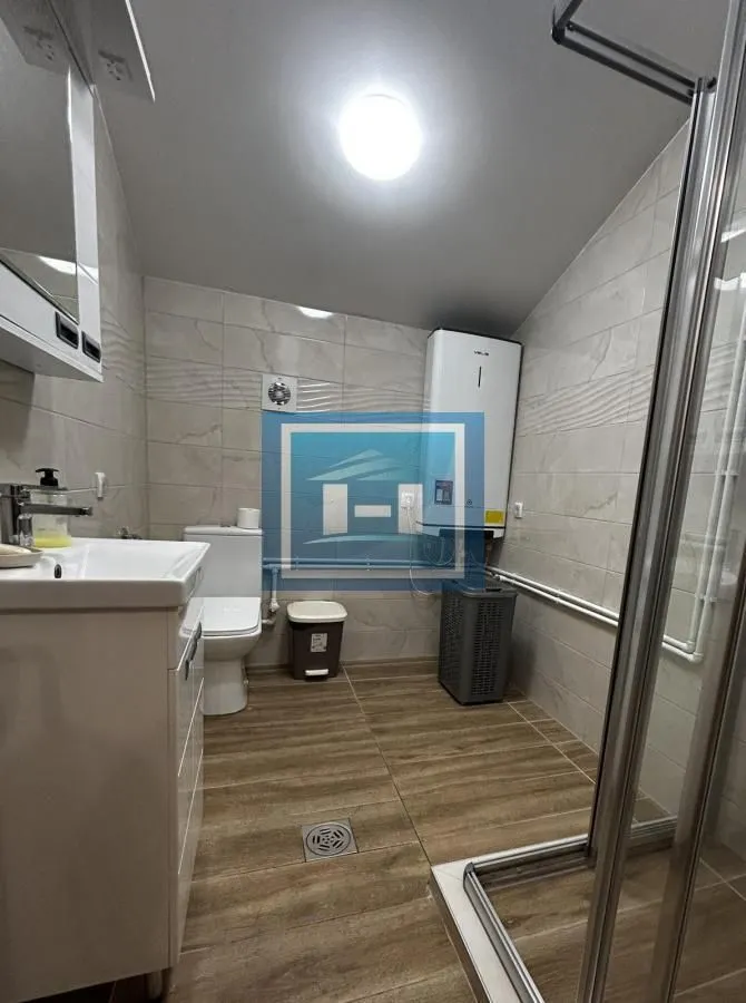 Kupatilo opremljeno tuš kabinom, umivaonikom i wc šoljom.