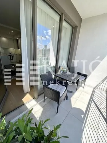 Furnished balcony with seating set and city view.