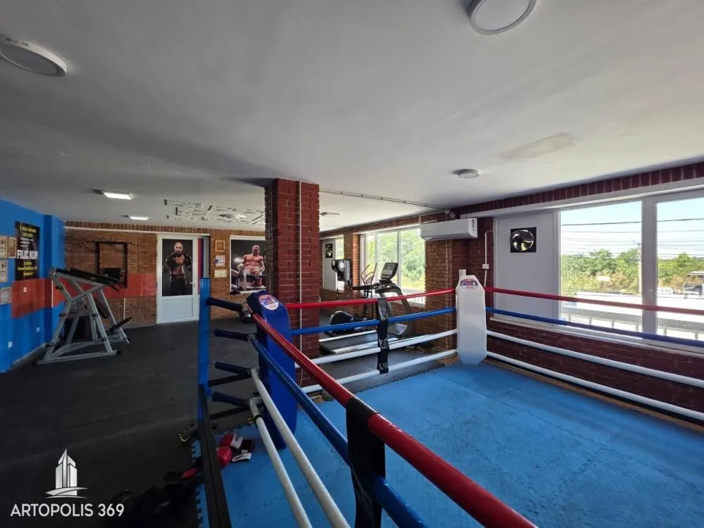 Interior of the gym with a boxing ring and exercise equipment.