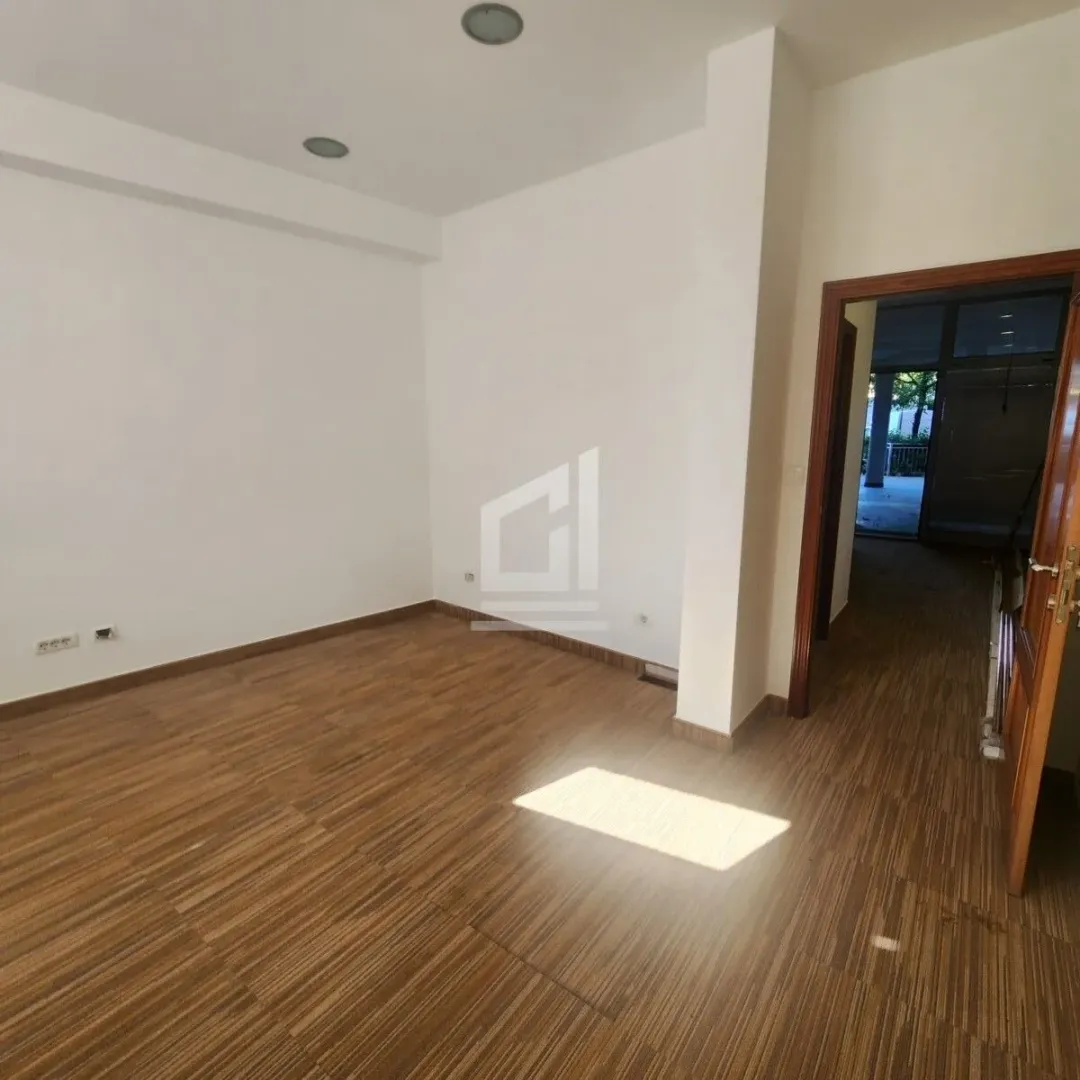 Empty room with wooden flooring and white walls.