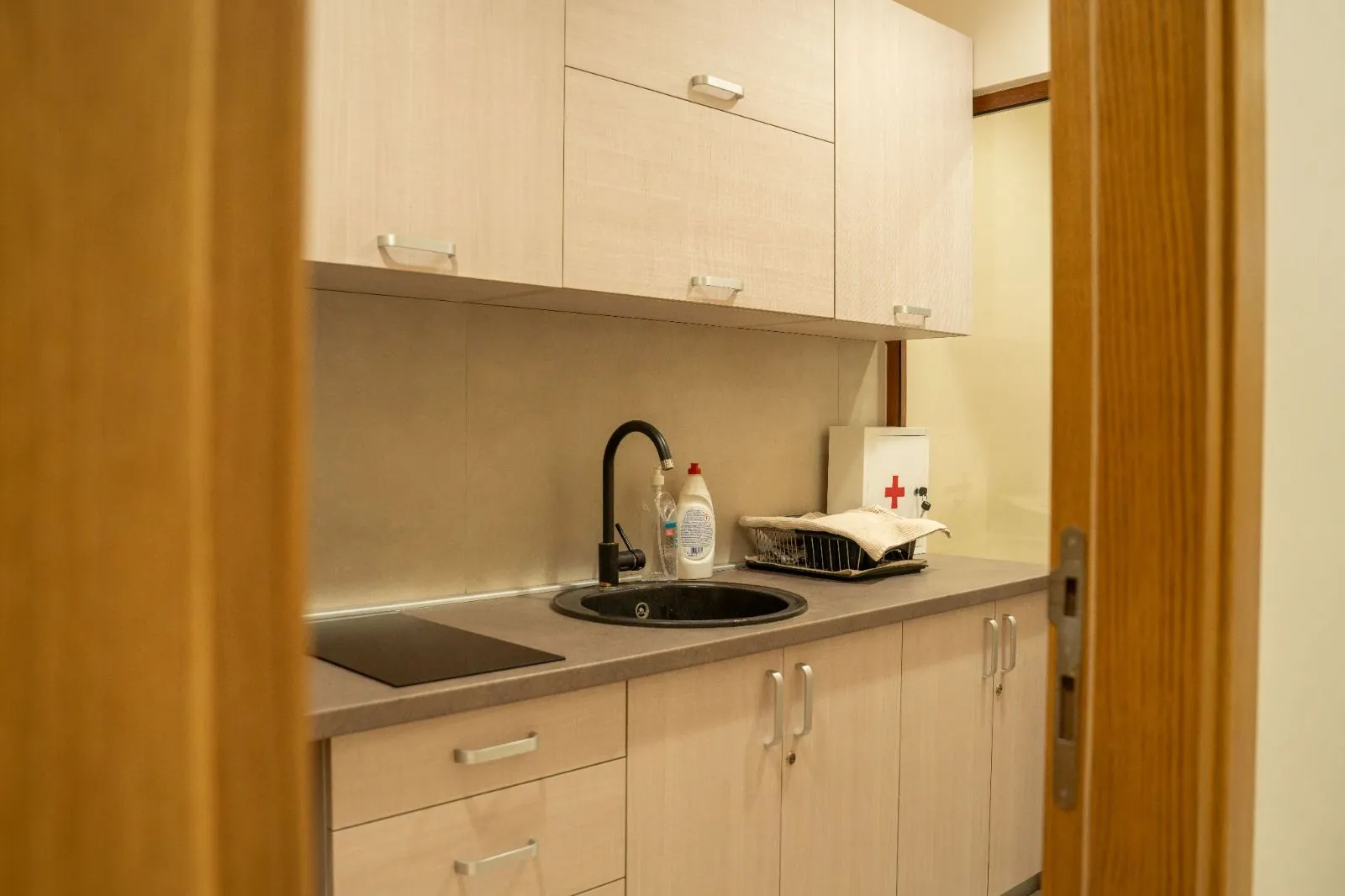 Smaller kitchen with wooden cabinets and a sink.