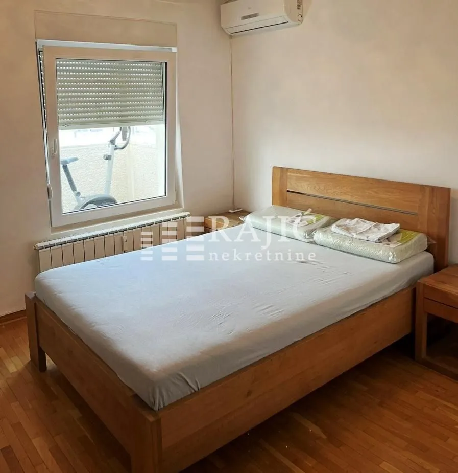 Bedroom with a wooden double bed and a window.