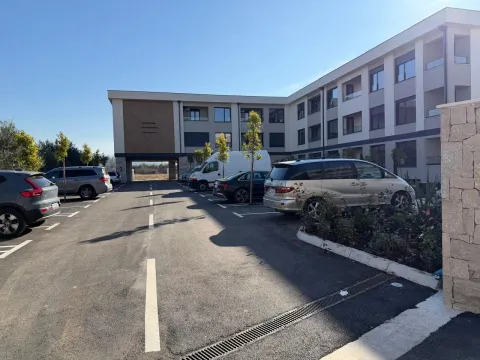 Spoljni parking prostor ispred stambene zgrade sa parkiranim automobilima. - image 2