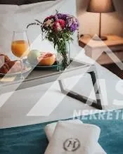 Krevet u spavaćoj sobi sa poslužavnikom za doručak i svežim cvećem. - image 5