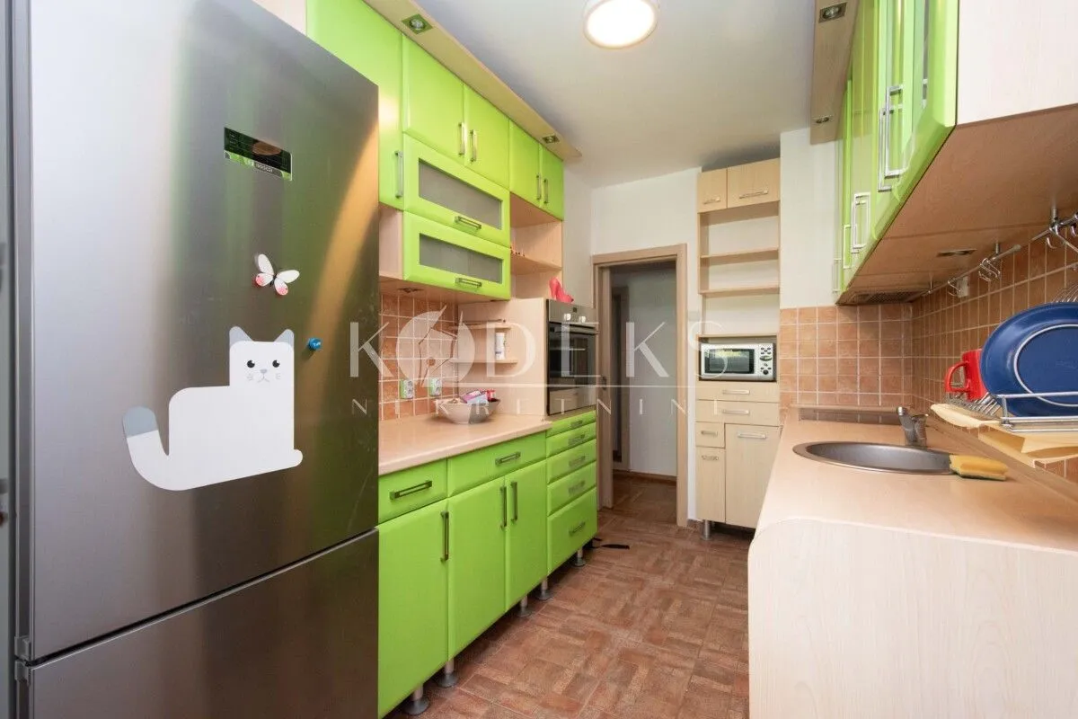 Kitchen equipped with green cabinetry and a stainless steel refrigerator.