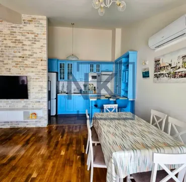 Living room with dining area and a blue kitchen. - image 2