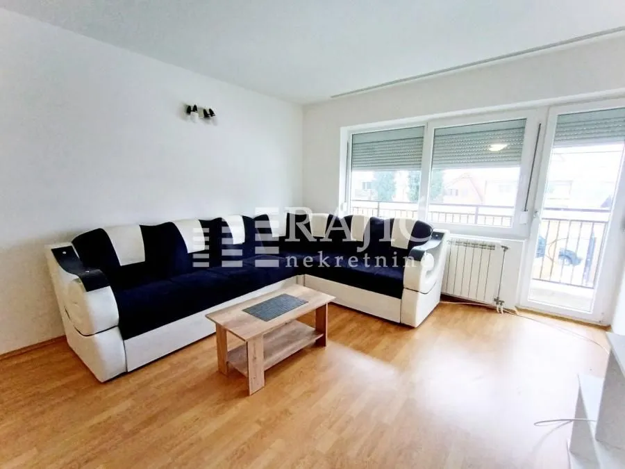 Living room with a corner sofa and a wooden coffee table.