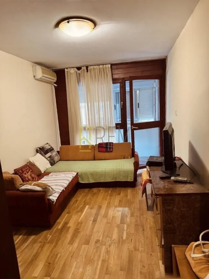 Dnevna soba sa garniturom i izlazom na terasu.