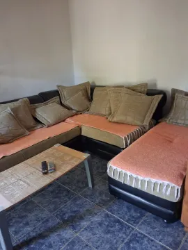 Living room with a sectional sofa and a coffee table. - image 6