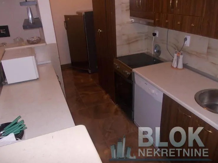Kitchen with wooden cabinets, sink, and built-in appliances.