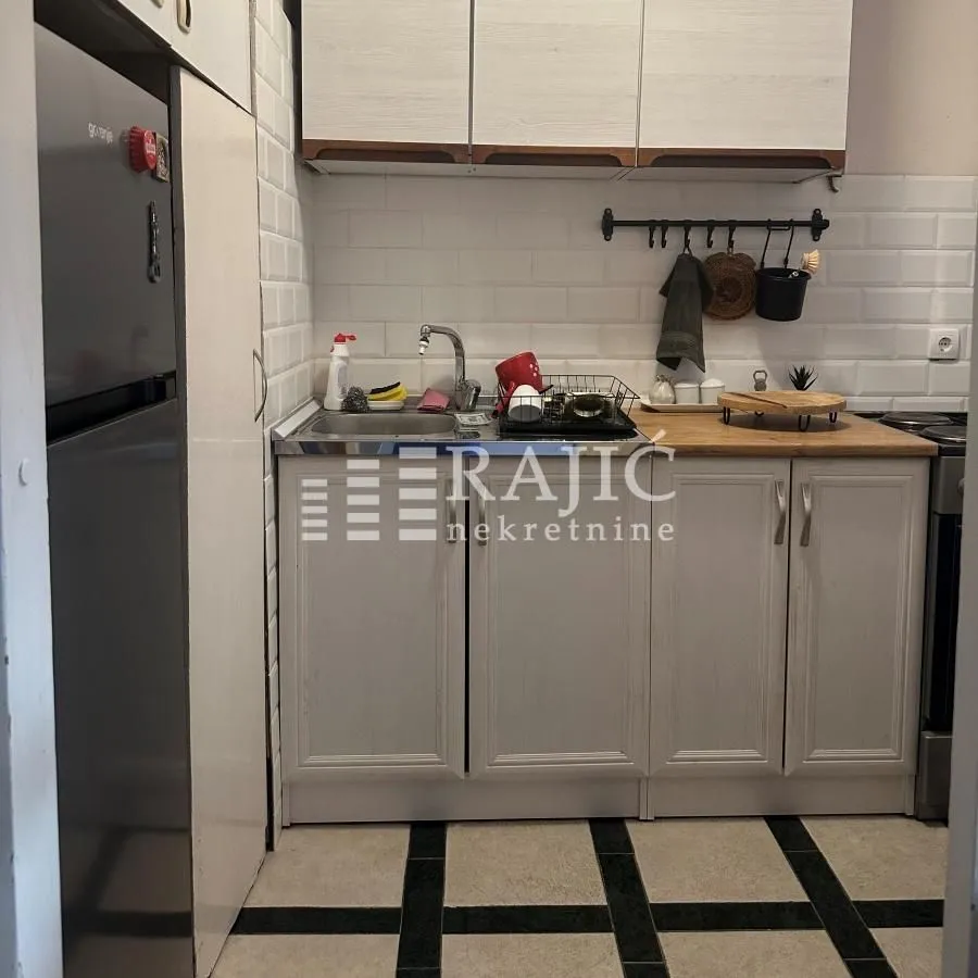 Small kitchen with light-colored cabinets and a sink.