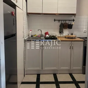 Small kitchen with light-colored cabinets and a sink. - image 11