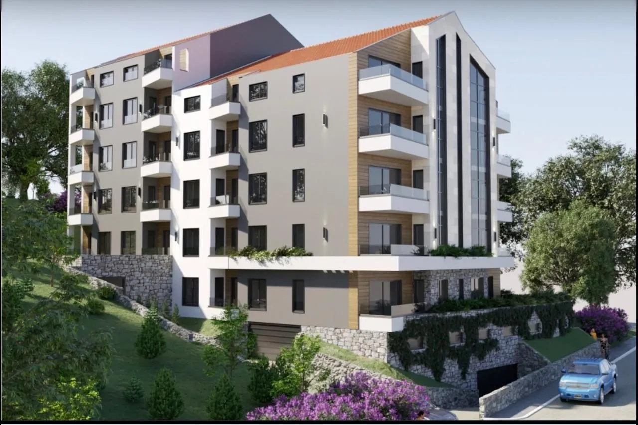 Spoljašnji izgled moderne stambene zgrade sa terasama i uređenim dvorištem.
