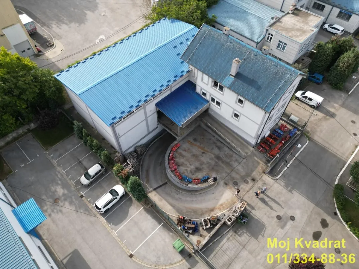 Aerial view of a commercial building with adjacent parking space.