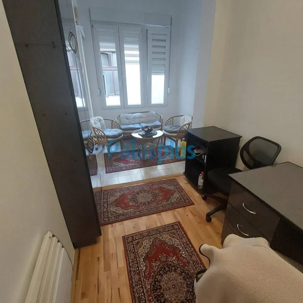 Living room with a desk and seating area by the window.