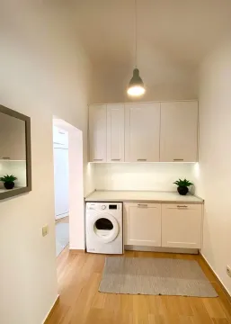 Small white kitchen with a built-in washing machine and upper cabinets. - image 8