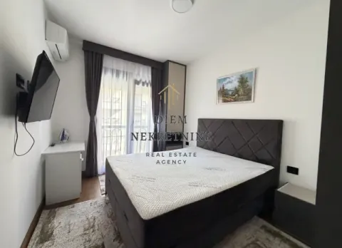 Namještena spavaća soba sa bračnim krevetom, TV-om i izlazom na terasu. - image 6