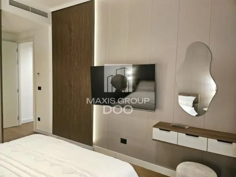 Modern bedroom with a double bed, TV, and a wall mirror. - image 9