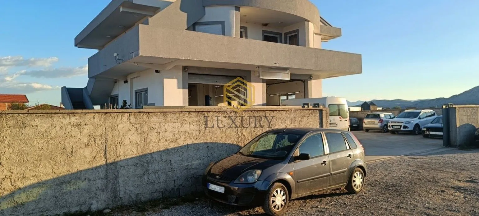Exterior of a multi-story house with a yard and parked cars.